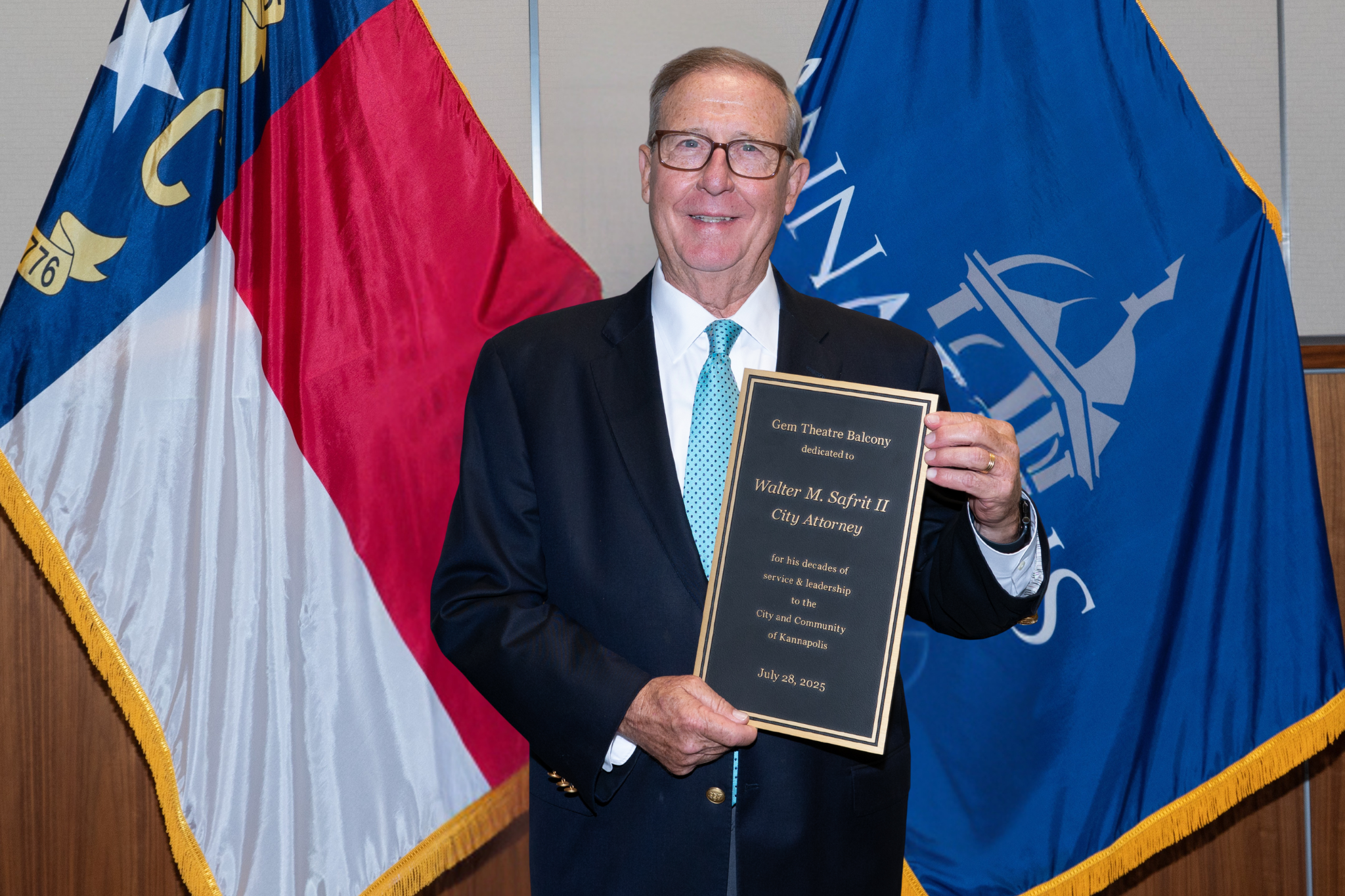Wally Safrit holding a plaque naming the Gem Theatre Balcony in his honor
